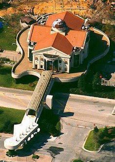 an aerial view of a house with a giant guitar on the roof and red tiled roofs