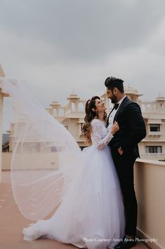 a bride and groom standing on a balcony