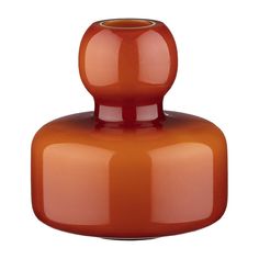 an orange vase sitting on top of a white table