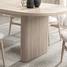 a table with two vases on top of it next to chairs and a rug