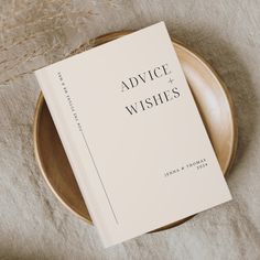 a book sitting on top of a wooden plate next to dry grass and dried flowers