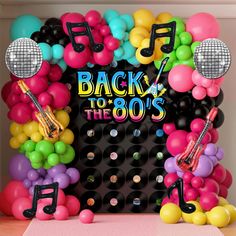 balloons and musical instruments decorate the backdrop for an 80's themed birthday party