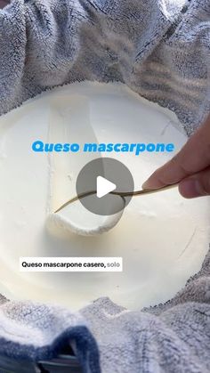 a person is using a knife to spread cream on top of a bowl with the words queso mascarpone