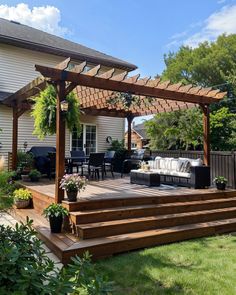 an outdoor patio with wooden steps and pergolated seating area in the back yard