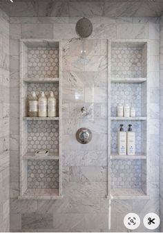 a bathroom with white marble walls and shelves