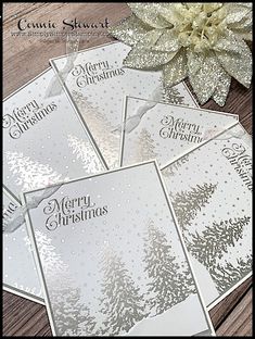 four christmas cards sitting on top of a wooden table