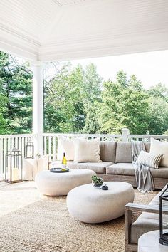 a living room filled with furniture on top of a wooden floor covered in white pillows