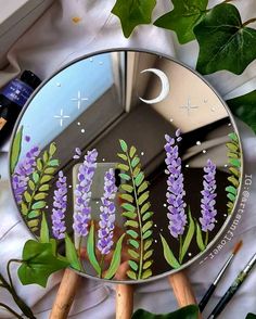 a mirror with purple flowers painted on it