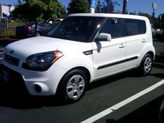 a white car is parked in a parking lot