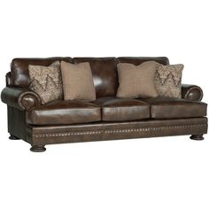 a brown leather couch with pillows on it