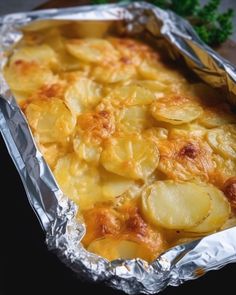 baked potato casserole in aluminum foil with parsley on the side, ready to be eaten