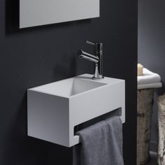 a white sink sitting under a mirror next to a towel rack