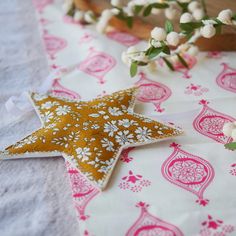 a decorative star ornament sitting on top of a pink and white table cloth