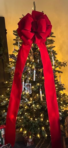 a christmas tree with a large red bow on it