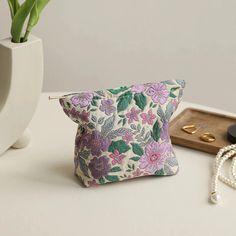 Timeless Elegance and Practicality Embrace the charm of vintage style with our Vintage Floral Cosmetic Bag. This beautifully designed cosmetic bag features an elegant purple flower pattern that adds a touch of sophistication to your everyday essentials. Whether you're heading to work, a weekend getaway, or a night out, this compact and stylish bag is your perfect companion. Perfect for Every Occasion Our Vintage Floral Cosmetic Bag is designed for versatility. Its small size makes it ideal for fitting into your handbag or luggage, ensuring you have your beauty essentials and more within reach wherever you go. Use it as a cosmetic bag, a coin purse, or even a commuter card holder. It's perfect for those who love to keep their items organized in style. High-Quality and Durable Crafted from p Purple Rectangular Cosmetic Bag For Daily Use, Purple Pouch Coin Purse For Daily Use, Purple Coin Purse For Daily Use, Purple Coin Purse With Zipper For Daily Use, Daily Use Purple Pouch Coin Purse, Purple Coin Purse Pouch, Feminine Cosmetic Pouch For Daily Use, Purple Rectangular Cosmetic Bag With Zipper, Purple Cosmetic Bag Pouch For Everyday Use