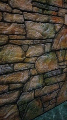 a stone wall with green and yellow colors