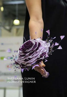 a woman holding a bouquet of purple flowers