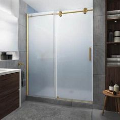 a bathroom with a walk in shower next to a white sink and brown cabinetry