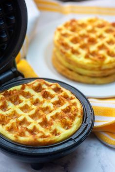 two waffles sitting on top of a plate next to some other food items