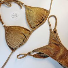 Top quality Bikini. Made in USA 2-3 week turn around time. Made to order Perfect for posing in and practicing in. Great for figure, wellness and bikini division. Also perfect for the beach and taking selfies in. Cute dainty gold rhinestone connector. Top cut is our triangle top, adjustable so you can gather top or not. Bottom back is Pro-cut and V-front cut. Top lined with cup hole for inserts. Bottom front has lining and the back is single layer, with scrunch butt to enhance glutes. Recommend- Hand wash & hang dry. No Refunds, returns and exchanges. Lining is sport lining with MaxDri moisture management & Anti-microbial Content: 80% Nylon, 20% Spandex 92%Polyester- 8% Spandex Competition Jewelry, Figure Suits, Posing Suits, Taking Selfies, Cut Top, Design Competitions, Suit Fabric, Gold Rhinestone, Triangle Top