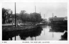 an old black and white photo of people sitting by the water