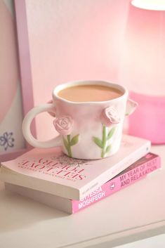 a cup of coffee sitting on top of two books