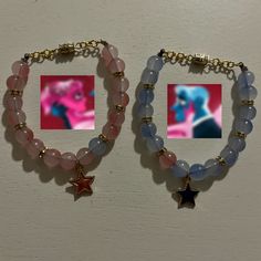 two bracelets with charms and pictures hanging from them on a white wall next to each other