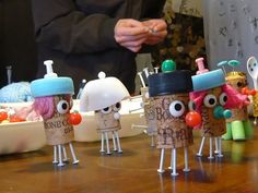 several small plastic toy figures on a table with food in bowls and spoons behind them