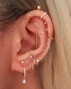 a woman's ear with different types of piercings