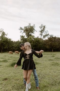 a man and woman are standing in the grass