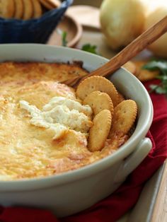 a bowl of dip with crackers and cheese