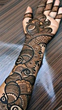 a woman's hand with henna tattoos on it