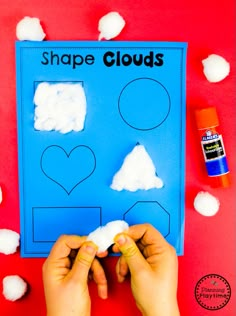 someone is making a shape cloud craft with cotton balls and glue on the table next to it