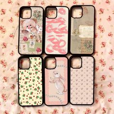 four cell phone cases sitting next to each other on a pink flowered bed sheet