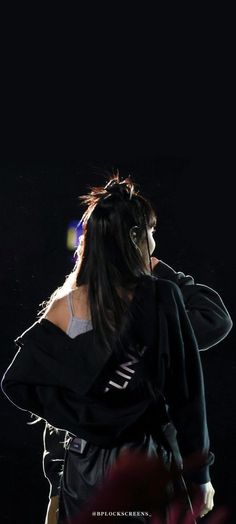 a woman with long hair standing in the dark