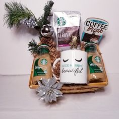 starbucks coffee mugs and other items in a basket with christmas decorations on the table