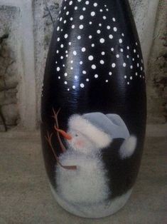 a black and white vase with a snowman painted on it