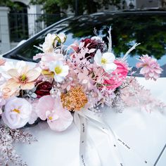 a bouquet of flowers sitting on the hood of a car