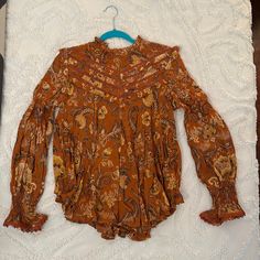 Nwt Aurora Blouse Size Medium. Sweet Ruffle Details On The Shoulders, Neck Line, Bust And Back. Ruched At The Wrists With Lace Trimmed Flare. Predominantly Rust Color With Tan And Brown Shades Throughout Orange Long Sleeve Blouse With Ruffles, Orange Long Sleeve Printed Tops, Orange Long Sleeve Top With Boho Print, Orange Printed Long Sleeve Tops, Orange Bohemian Blouse With Floral Print, Flowy Brown Blouse For Fall, Bohemian Orange Printed Blouse, Orange Long Sleeve Blouse With Floral Print, Vintage Boho Print Top For Fall