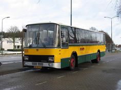 a yellow and green bus is parked on the street