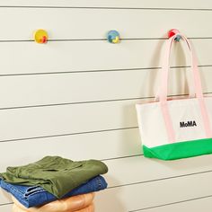 a tote bag hanging on the wall next to clothes and jeans in front of it