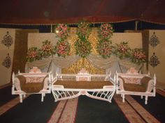 a living room filled with furniture and flowers on the wall next to a rug covered floor