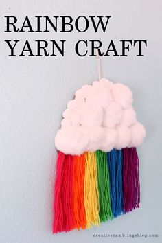 a rainbow yarn craft hanging on the wall with text overlay that reads, rainbow yarn craft