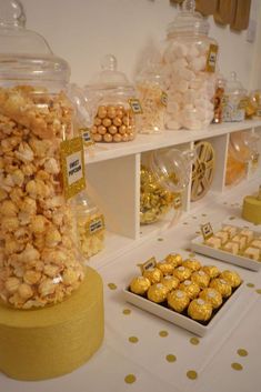 a table topped with lots of candy and candies next to shelves filled with sweets