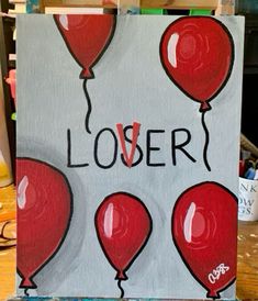 a painting with red balloons and the words lover written on it in black ink, sitting on a easel