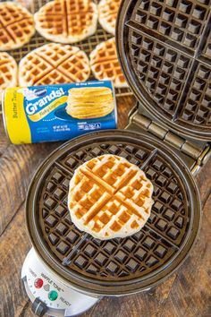 two waffles with butter on top sitting on a table next to a carton of creme