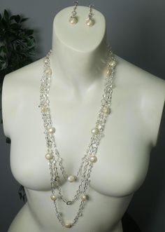 An abstract silver chain is strung to clear beads and brushed cream pearls to form this lovely set. Featuring unique diamond silver chain details and clear gems that are plated around the crystal! These two pieces are magnificent and are sure to stand out! Handmade and supports future art! Elegant Crystal Necklace With Pearl Chain, Silver Crystal Pearl Necklace As A Gift, Silver Crystal Pearl Necklace Gift, Silver Crystal Pearl Necklace For Gift, Elegant Crystal Jewelry With Pearl Chain, Party Silver Jewelry With Pearl Chain, Silver Pearl Chain Jewelry For Party, Long Silver Pearl Necklace For Party, Glamorous Round Pearl Jewelry