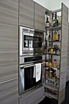 a kitchen with stainless steel appliances and shelves full of food, drinks and condiments