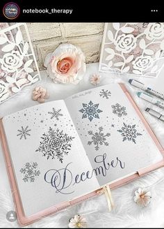 an open book with snowflakes on it and the words december written in cursive writing