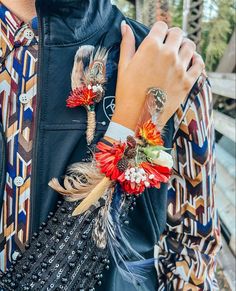 a person wearing a jacket with feathers and flowers on it's cufflinks